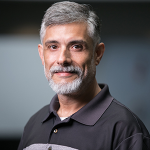 Ed McFadden, wearing a collared t-shirt and smiling