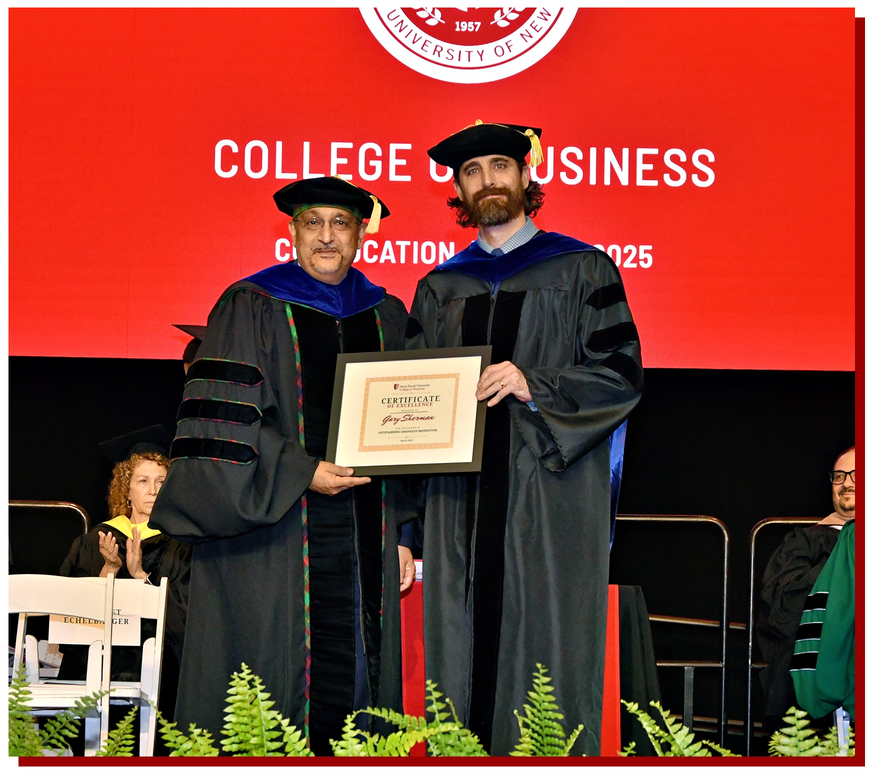 College of Business Graduate Walking Across the Stage with Diploma in hand