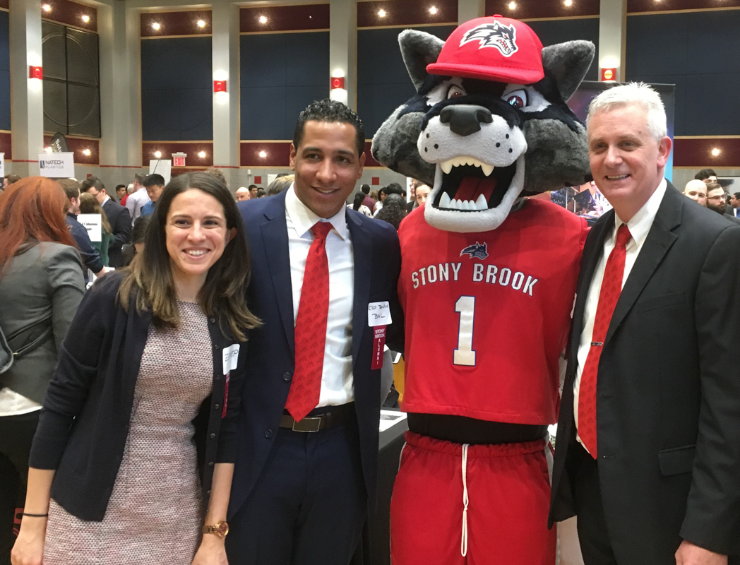 Zeynep (left) at a Stony Brook University job fair along with two other alumni who also work at BNL
