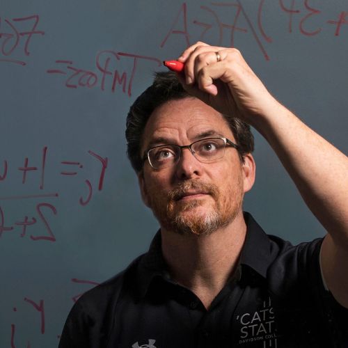 Tim Chartier solving an equation with dry erase markers